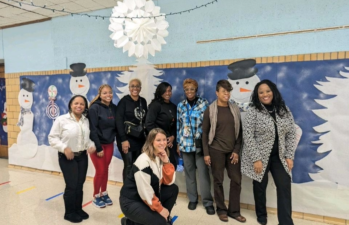  teachers standing in front of snowman with a blue background